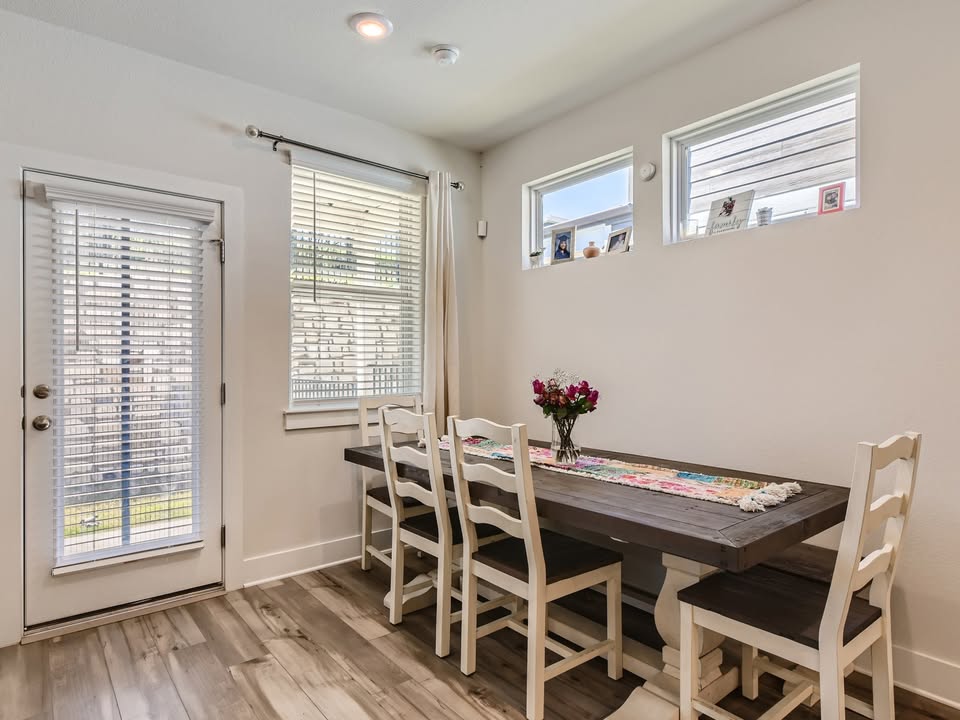 7103 Terrazzo Cottage Lane, Unit 33 Austin, TX 78744 - Photo 5 of 14 a view of a dining room with furniture and wooden floor