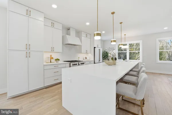 a kitchen with stainless steel appliances a stove a sink dishwasher and a refrigerator with wooden floor