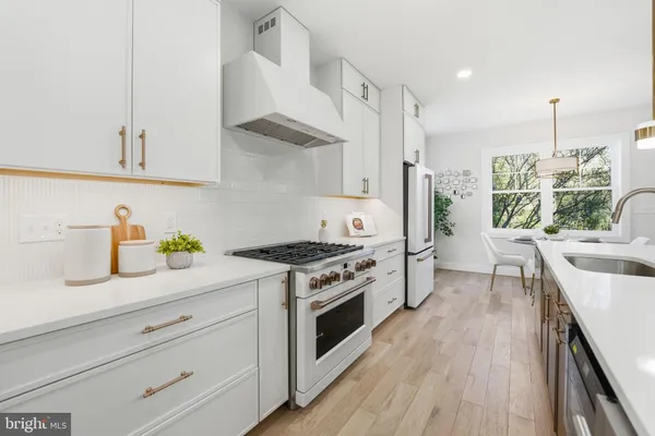 a kitchen with stainless steel appliances granite countertop a stove a sink dishwasher and a wooden cabinets
