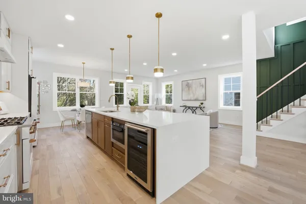 a kitchen with kitchen island a white counter top space a sink appliances and cabinets
