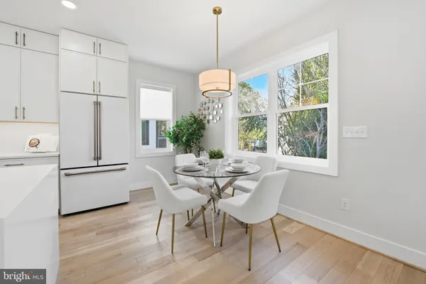 a living room with furniture kitchen view and a chandelier