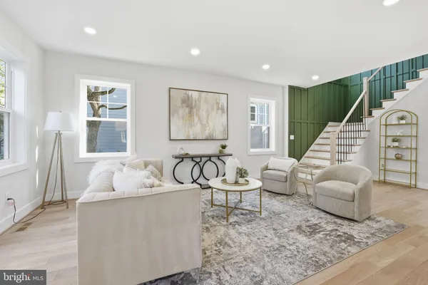 a living room with furniture kitchen and a large window