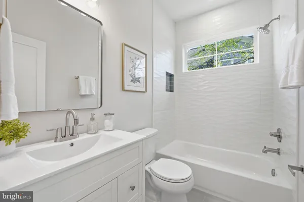 a bathroom with a toilet sink vanity and mirror