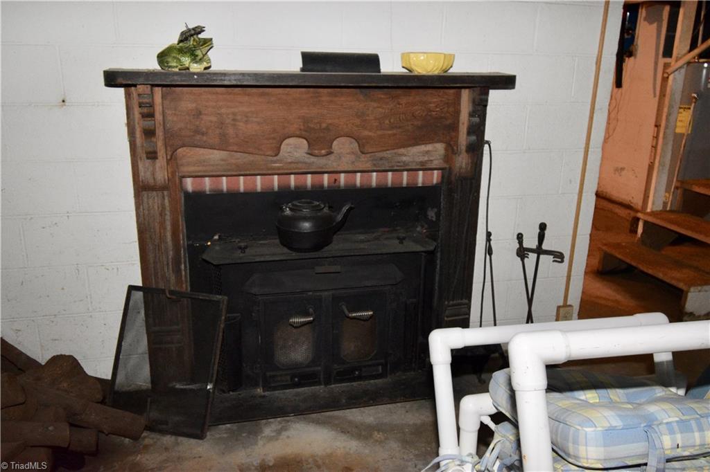 6556 Foster Road Whitsett, NC 27377 - Photo 24 of 27 Fireplace in basement has wood insert.