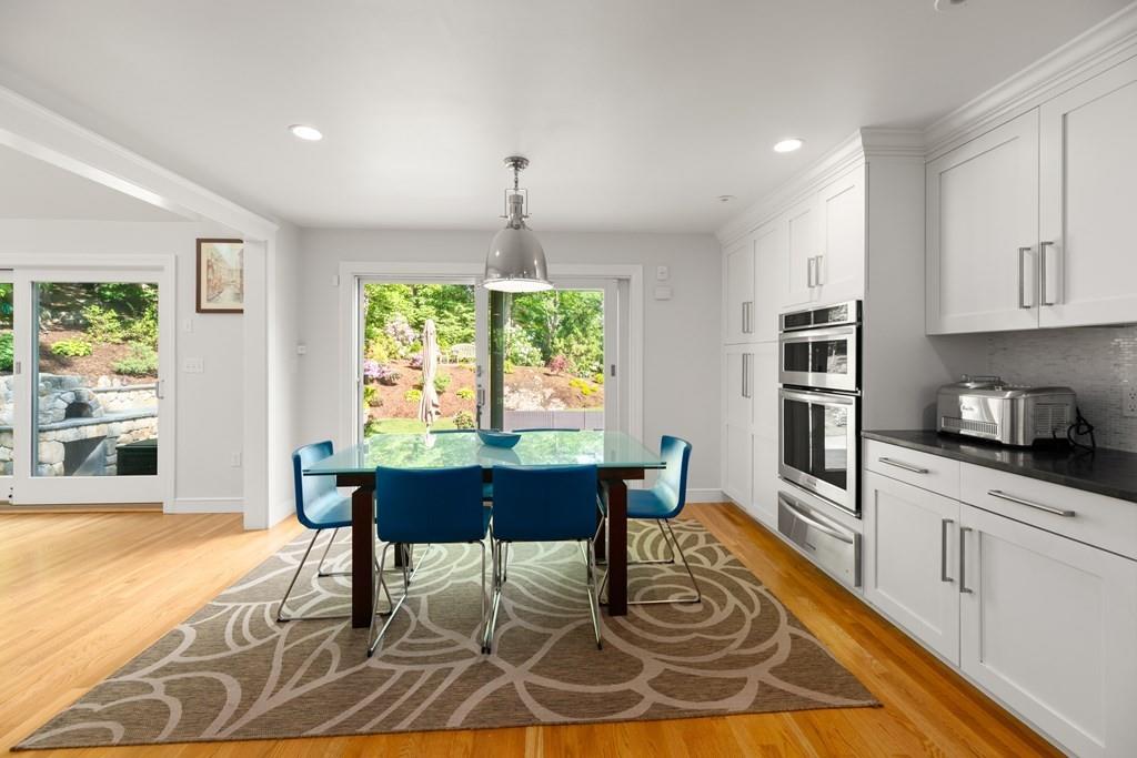 77 Royalston Road Wellesley, MA 02481 - Photo 7 of 30 a kitchen with stainless steel appliances granite countertop a stove a sink a dining table and chairs with wooden floor