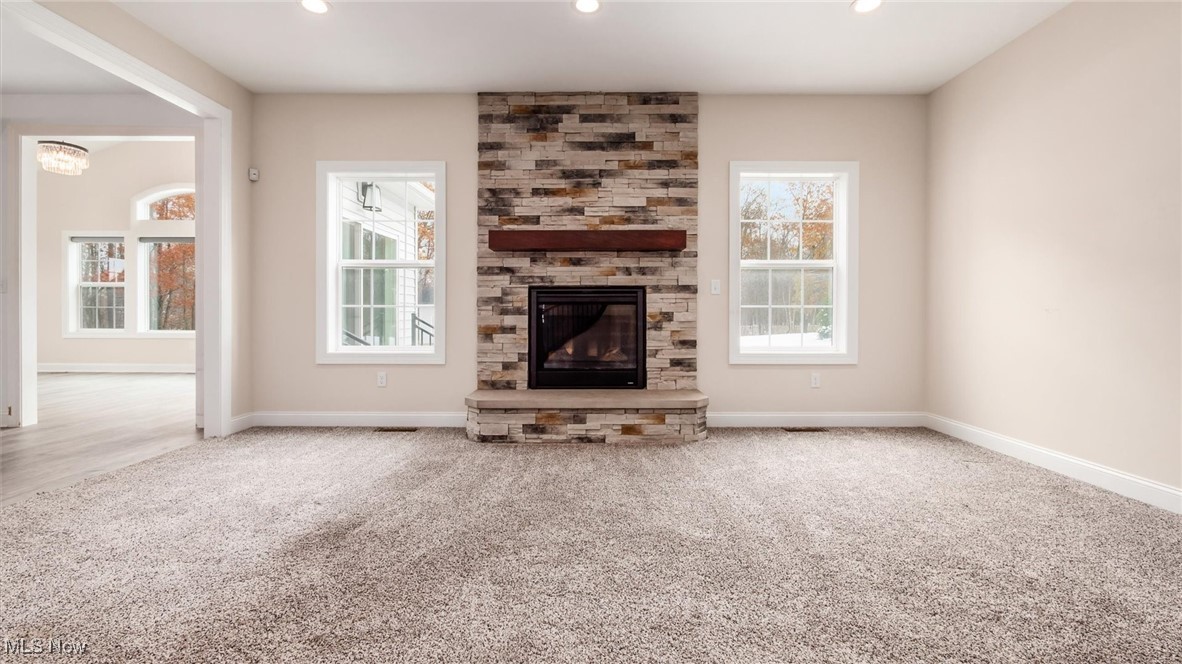 4641 Foote Road Medina, OH 44256 - Photo 11 of 46 Unfurnished living room featuring carpet flooring, a stone fireplace, plenty of natural light, and recessed lighting