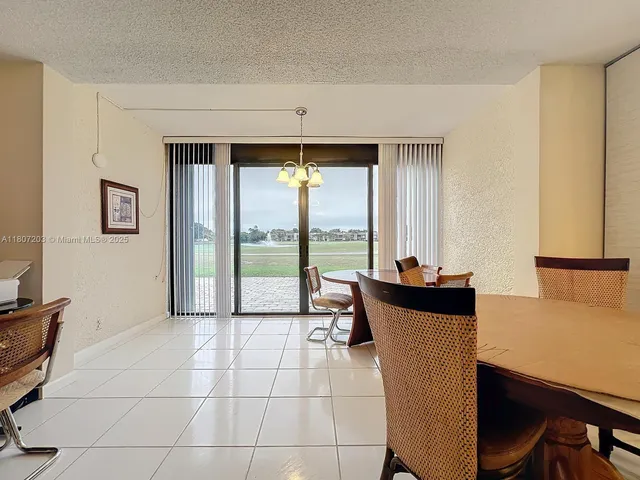 a dining room with furniture and a floor to ceiling window