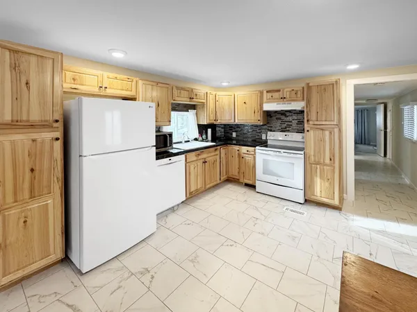 a kitchen with granite countertop cabinets and refrigerator
