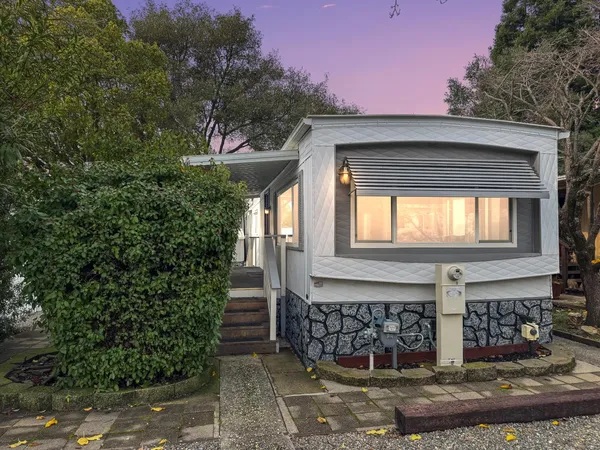 a front view of a house with plants and entryway