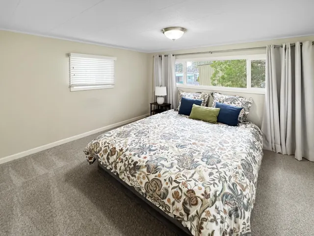 a bed sitting in a bedroom next to a window