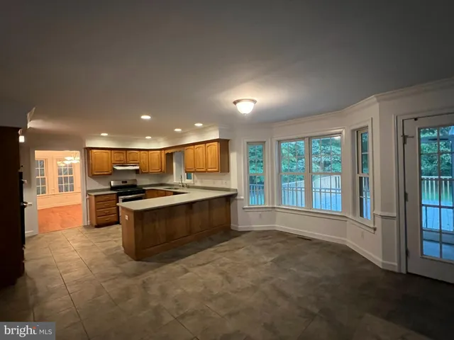 a large white kitchen with stainless steel appliances granite countertop a stove and a refrigerator