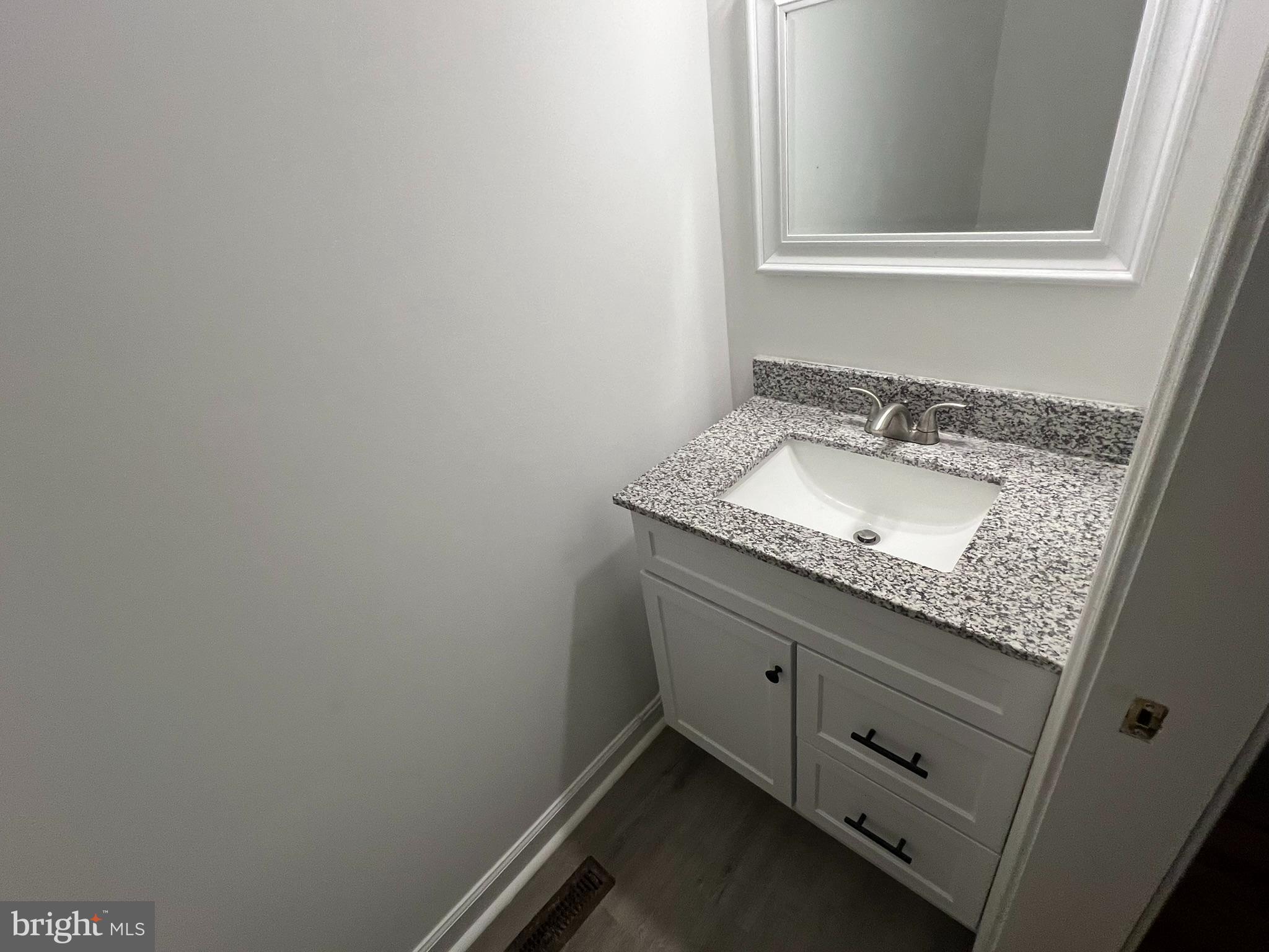 1290 College Road Dover, DE 19904 - Photo 24 of 33 a bathroom with a granite countertop sink and a mirror