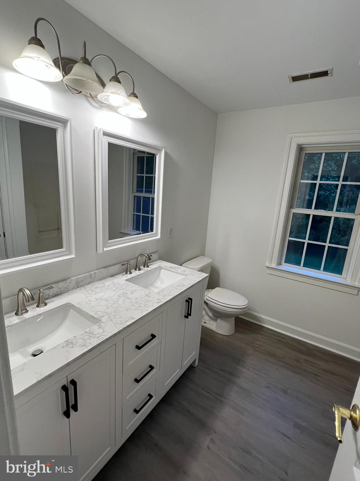 1290 College Road Dover, DE 19904 - Photo 26 of 33 a bathroom with a granite countertop sink a toilet a mirror and a window