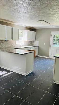 a view of a kitchen with kitchen island a sink wooden floor and a counter top space