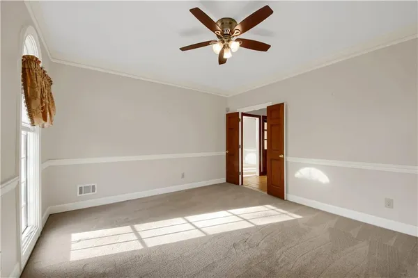 a view of empty room with wooden floor and ceiling fan