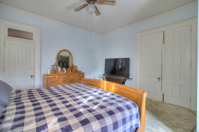 a bedroom with a bed and dresser with mirror