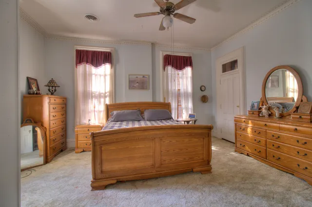 a bedroom with a bed flat screen tv and couches