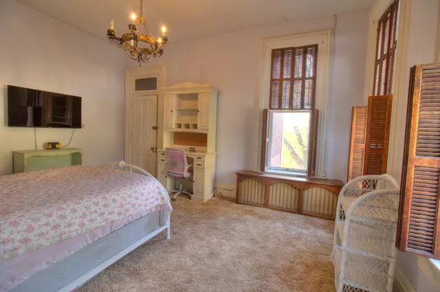 a bedroom with a bed table and window