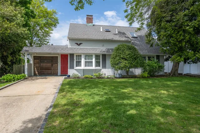 a front view of a house with a garden and plants