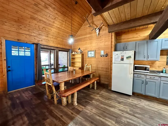 a kitchen with granite countertop wooden floors and white stainless steel appliances
