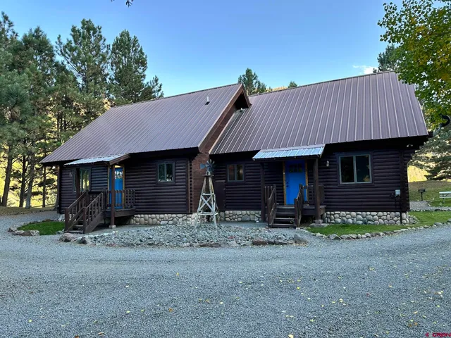 a view of a house with a yard and sitting area