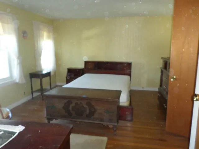 a bed sitting in a bedroom next to a window