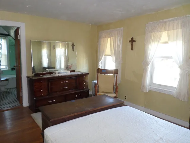 a bedroom with a bed and a mirror on dresser