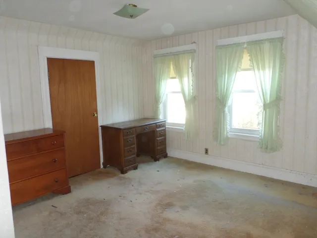 an empty room with windows and closet