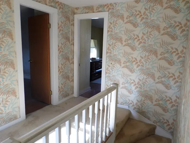 a view of a hallway with wooden floor and stairs