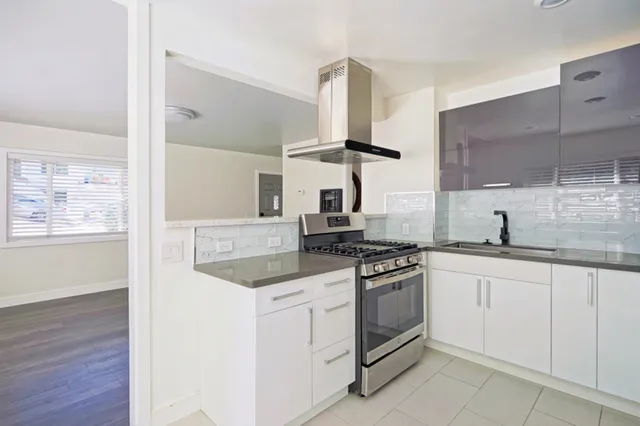 a kitchen with white cabinets and appliances