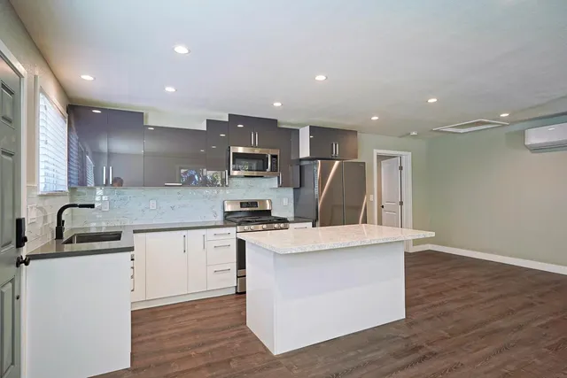 a kitchen with stainless steel appliances granite countertop a sink stove and refrigerator