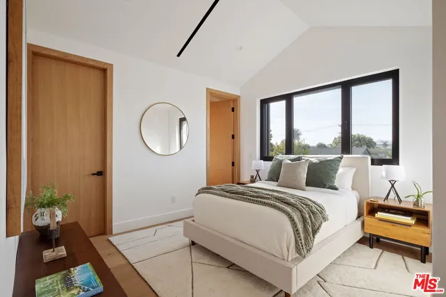 a bedroom with two beds and a large window