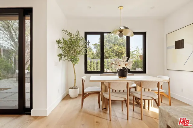a large kitchen with kitchen island sink large window and cabinets