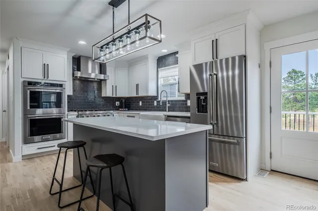 a kitchen with stainless steel appliances granite countertop a sink refrigerator and cabinets