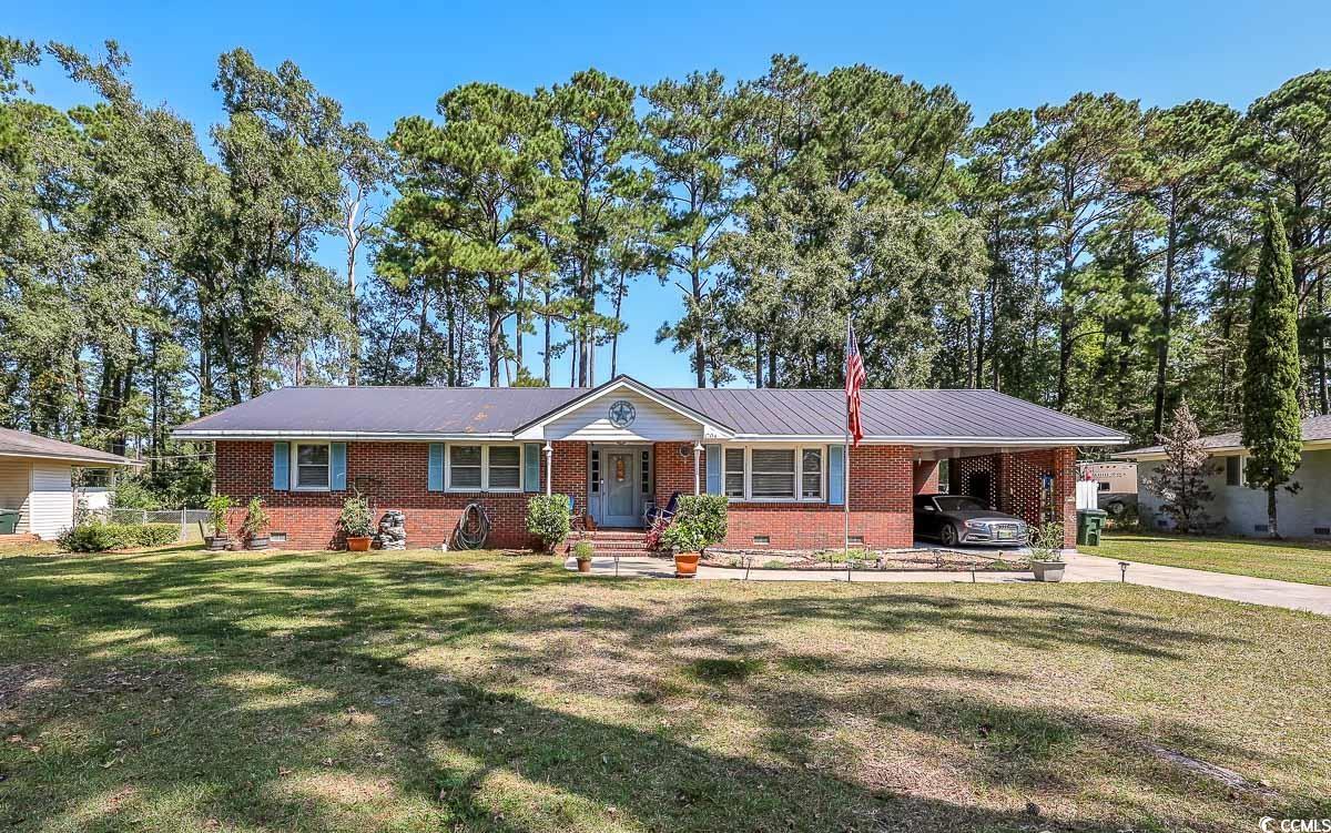Ranch-style house with an attached carport, brick siding, a front yard, crawl space, and driveway