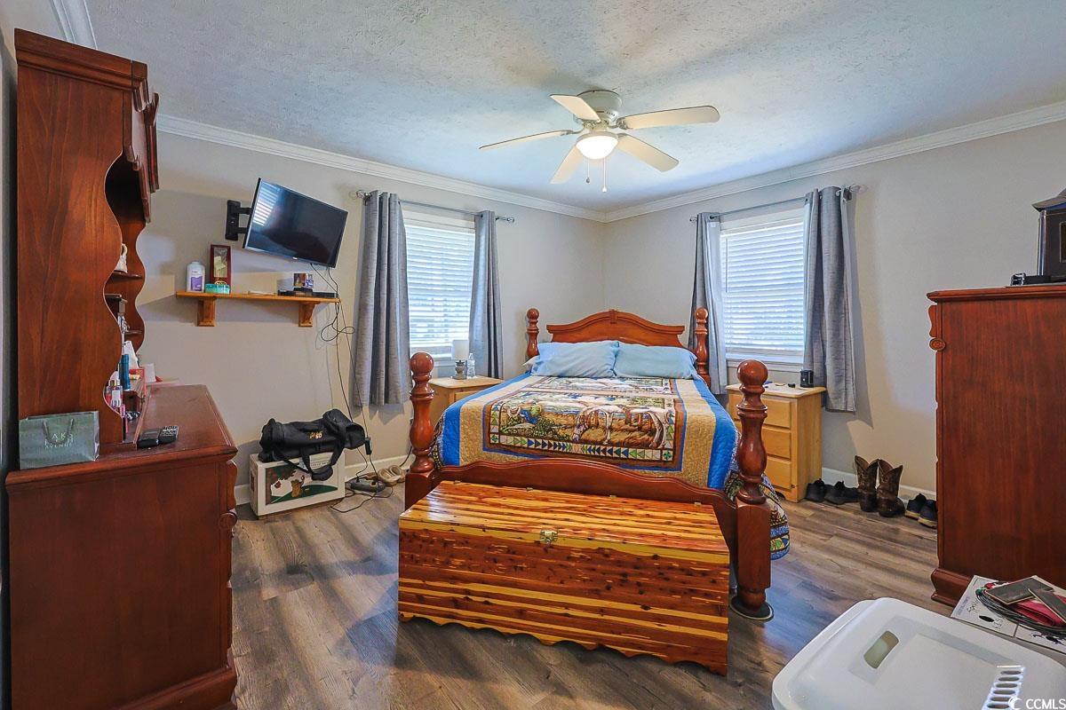 1704 Sherwood Drive Conway, SC 29526 - Photo 14 of 32 Bedroom with dark wood-style flooring, a textured ceiling, multiple windows, ornamental molding, and ceiling fan