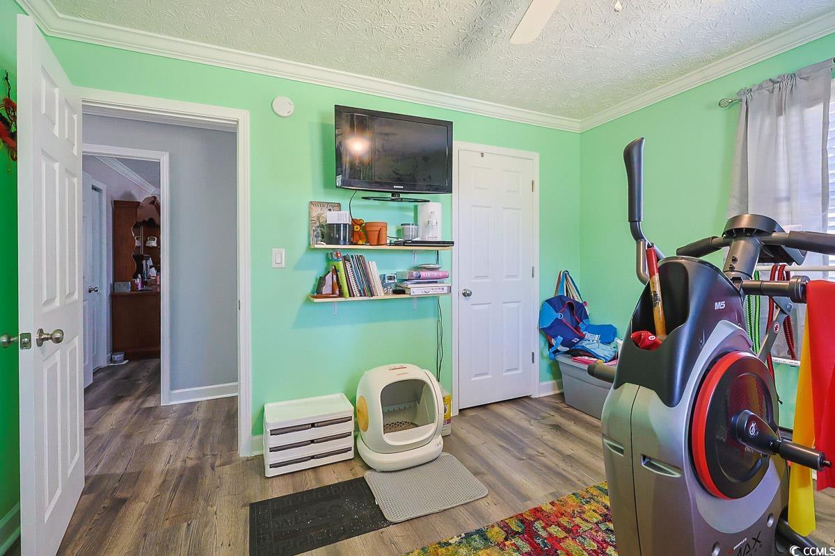 1704 Sherwood Drive Conway, SC 29526 - Photo 19 of 32 Bedroom featuring crown molding, a textured ceiling, dark wood-style flooring, and a ceiling fan