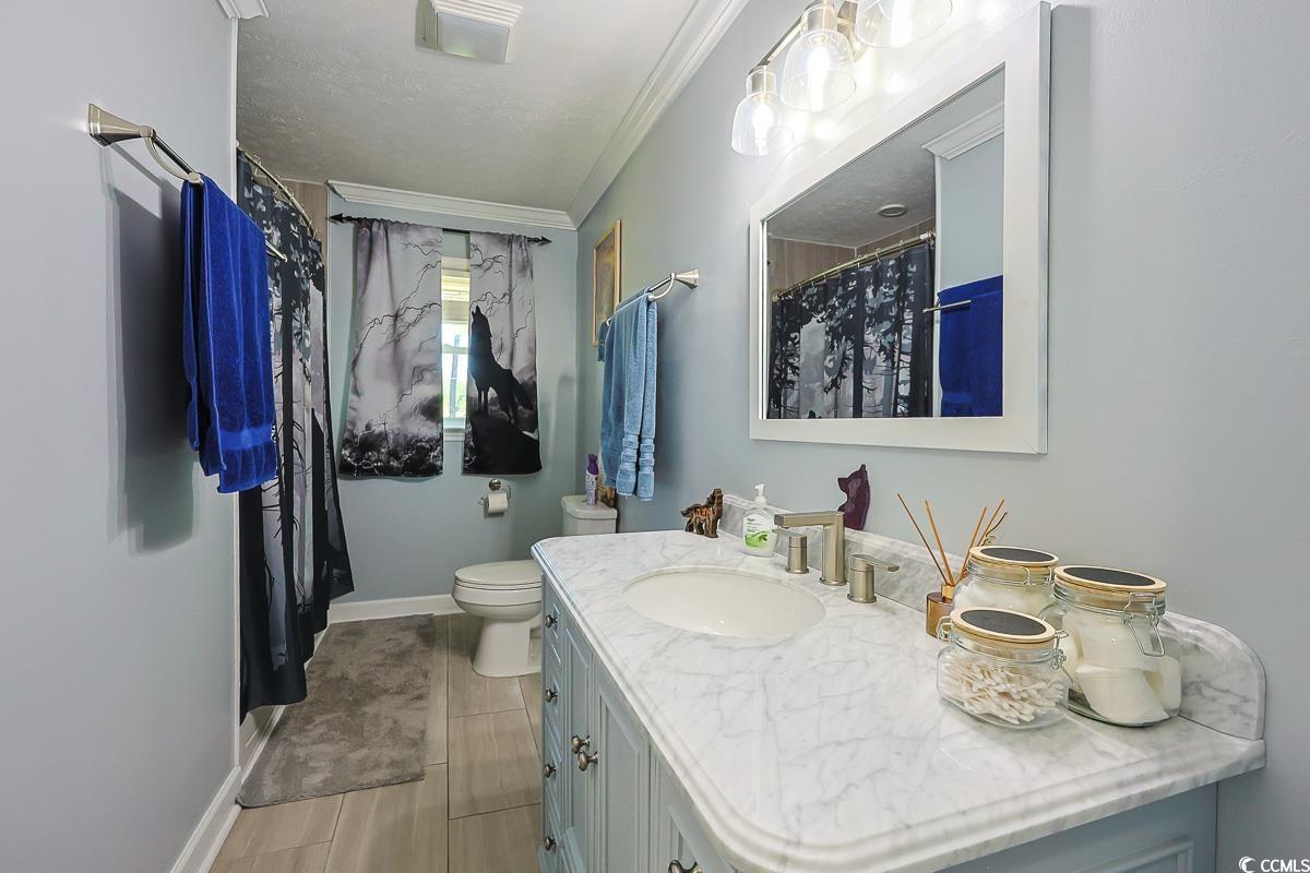 1704 Sherwood Drive Conway, SC 29526 - Photo 20 of 32 Full bath with vanity, ornamental molding, a shower with curtain, and light tile patterned floors