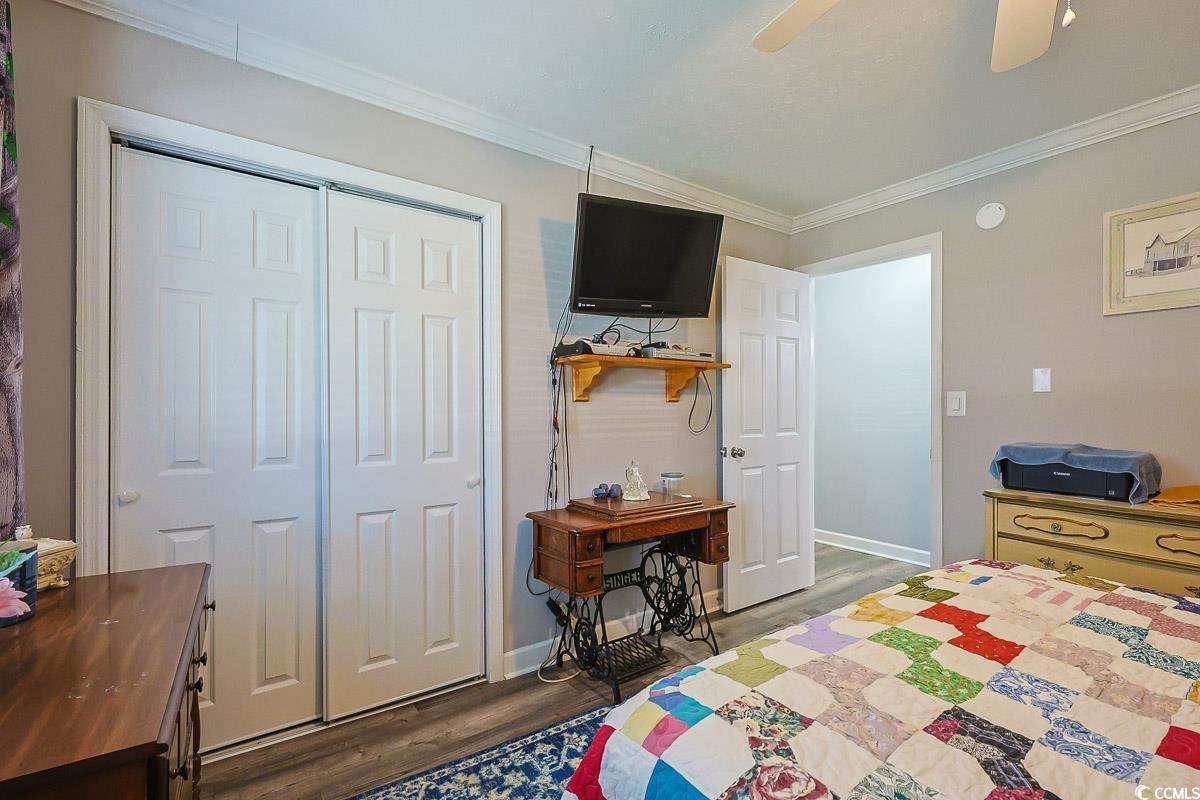 1704 Sherwood Drive Conway, SC 29526 - Photo 22 of 32 Bedroom featuring crown molding, dark wood finished floors, ceiling fan, and a closet