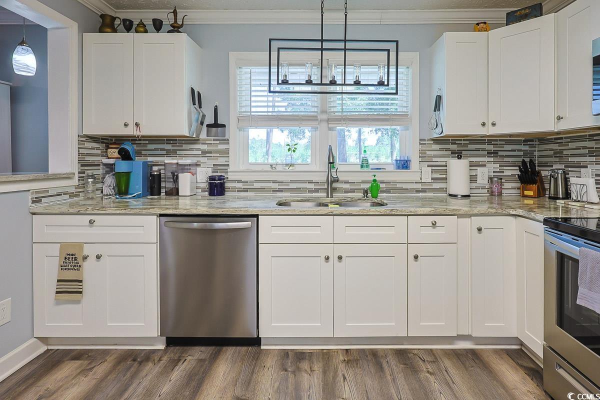 1704 Sherwood Drive Conway, SC 29526 - Photo 4 of 32 Kitchen with white cabinets, stainless steel appliances, light stone counters, ornamental molding, and decorative backsplash