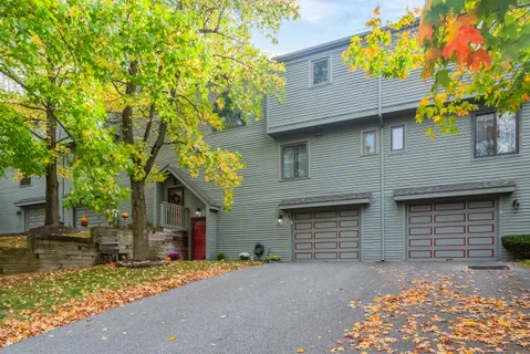 a front view of a house with a tree