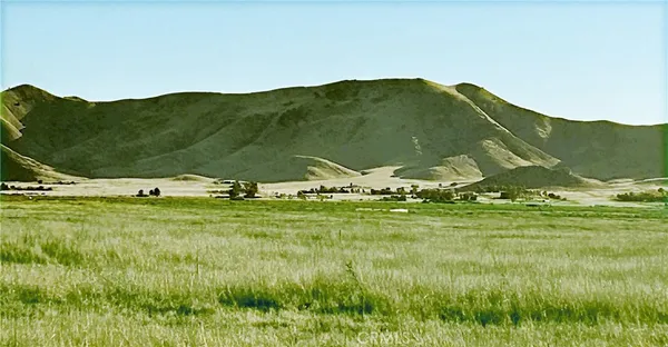 a view of a mountain with a field