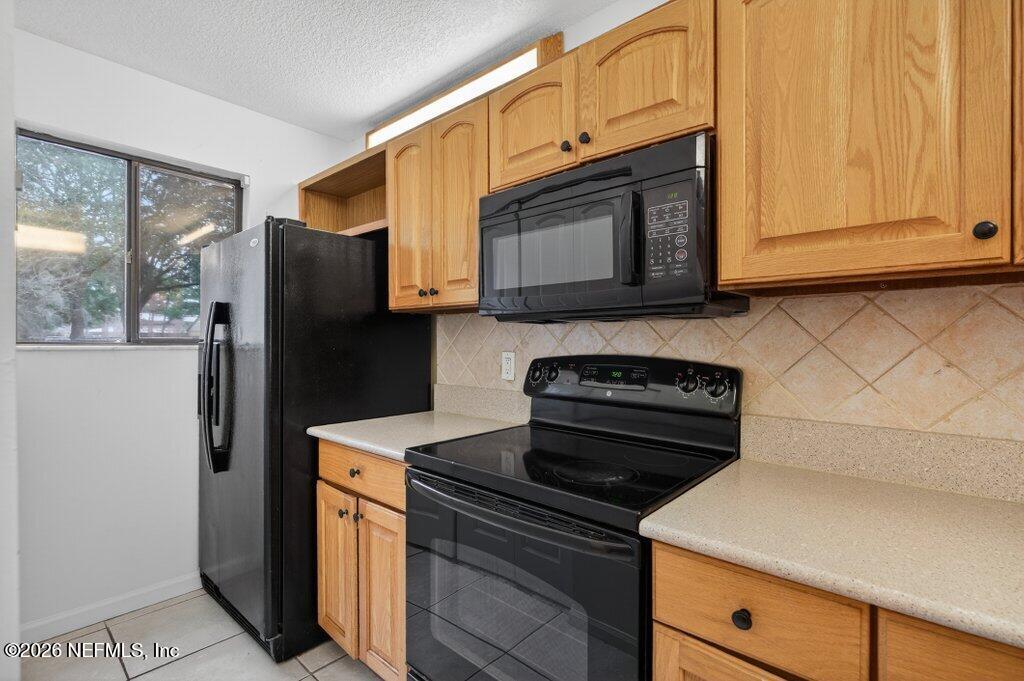 3801 Crown Point Road, Unit 2072 Jacksonville, FL 32257 - Photo 11 of 38 a kitchen with stainless steel appliances granite countertop white cabinets and a stove