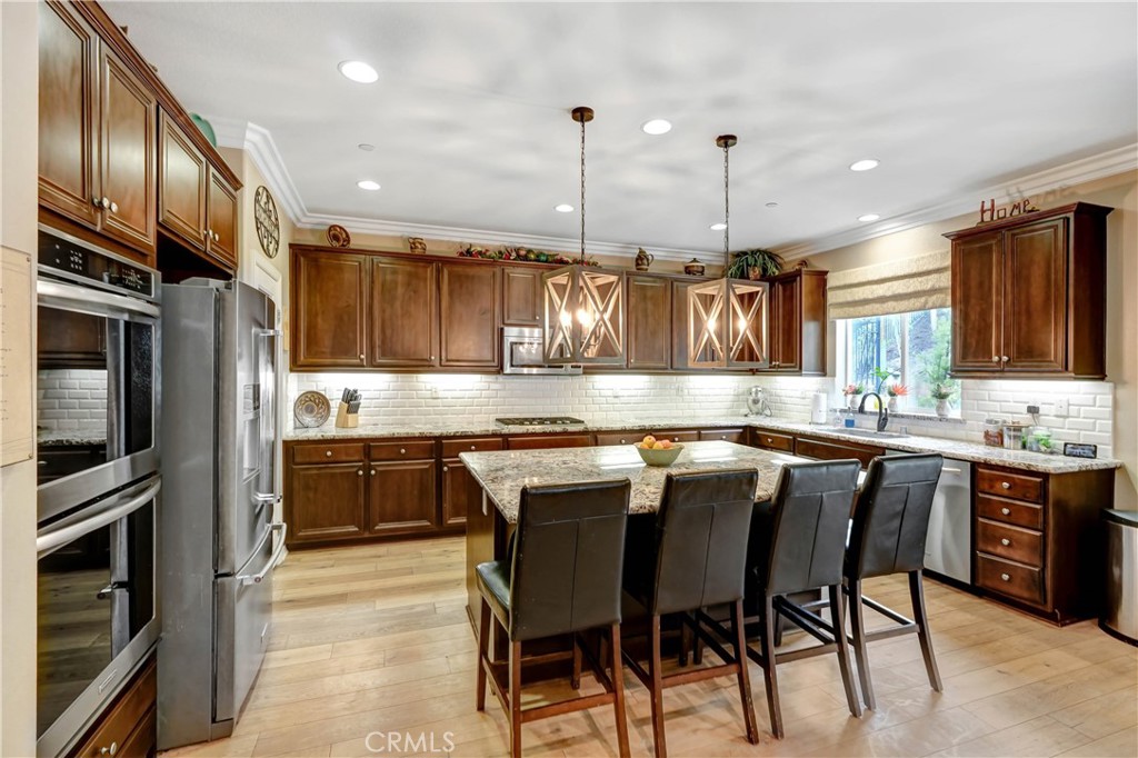 44260 Nighthawk Pass Temecula, CA 92592 - Photo 14 of 55 a kitchen with granite countertop a center island stainless steel appliances and cabinets
