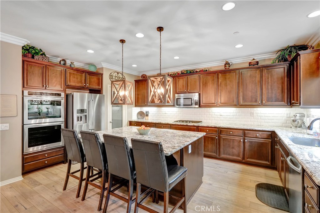 44260 Nighthawk Pass Temecula, CA 92592 - Photo 2 of 55 a kitchen with stainless steel appliances granite countertop a stove top oven a sink dishwasher and a refrigerator with wooden cabinets