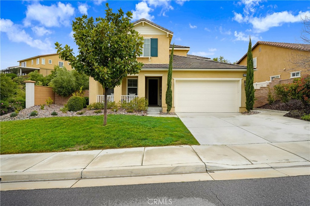 44260 Nighthawk Pass Temecula, CA 92592 - Photo 45 of 55 a front view of a house with a garden and a tree