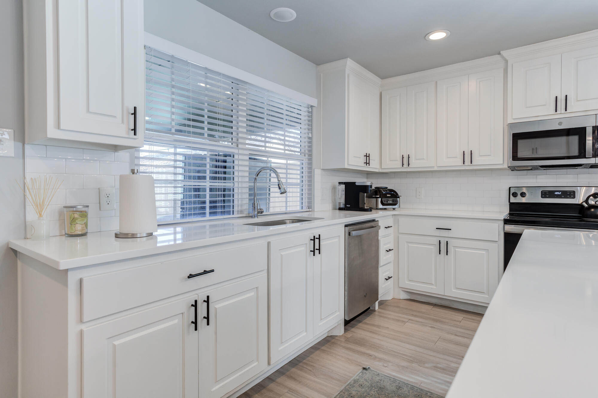 2414 25th Street Lubbock, TX 79411 - Photo 18 of 61 a kitchen with white cabinets and white appliances