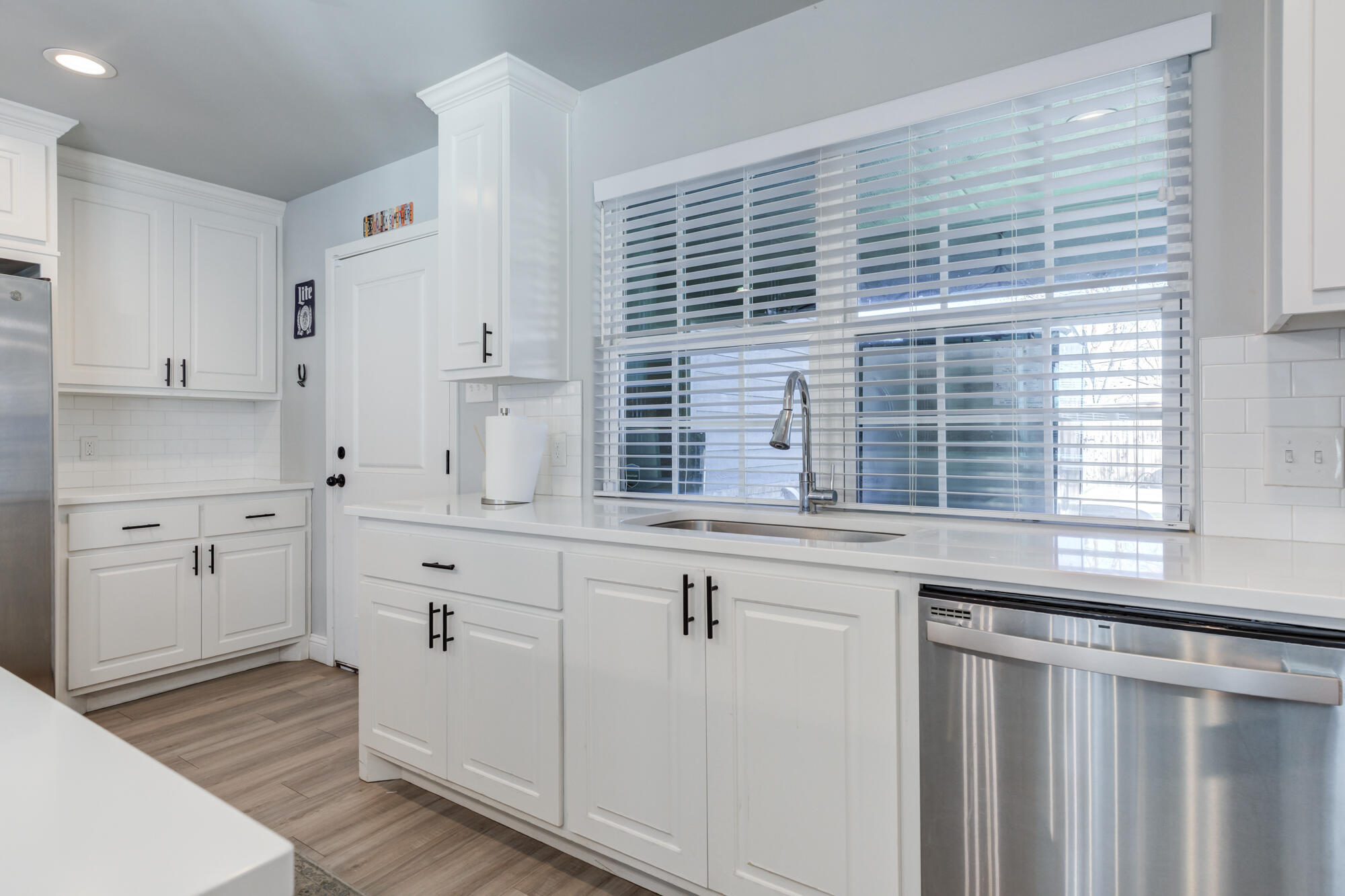 2414 25th Street Lubbock, TX 79411 - Photo 21 of 61 a kitchen with granite countertop white cabinets and white appliances