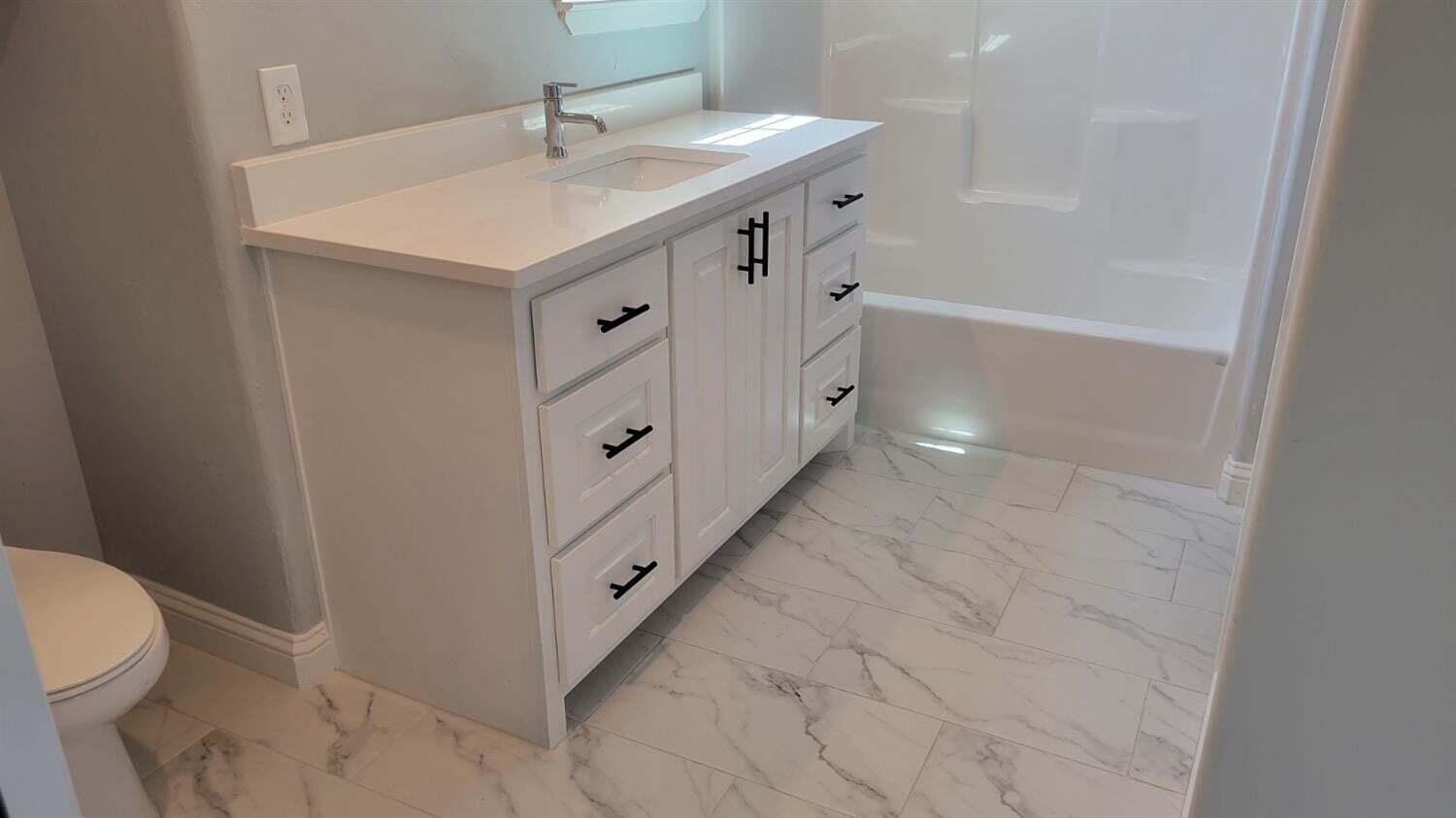 2414 25th Street Lubbock, TX 79411 - Photo 30 of 61 a bathroom with a sink a toilet and shower