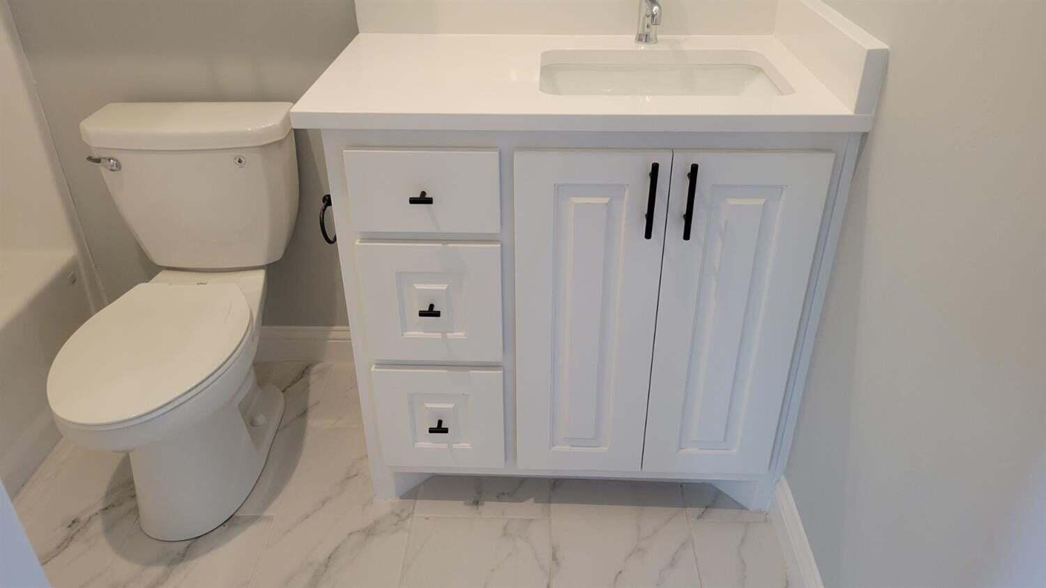 2414 25th Street Lubbock, TX 79411 - Photo 38 of 61 a bathroom with a toilet a sink and mirror